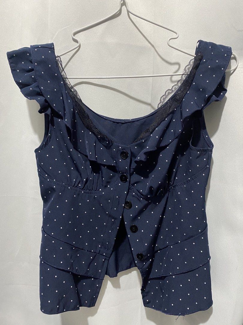 Navy Blue Polka Dot Ruffle Peplum Top (Category: Blouses) located in Binangonan. Submitted by lovegenn (Listing ID 1468545820, Image 1). Description: - Color: Navy blue with white polka dots - Design: Scoop neckline with black lace trim, button-down front with 5 black buttons - Sleeves: Ruffled cap sleeves - Cut: Peplum waist flare with layered hemline - Fabric: Lightweight and comfortable - Styling tip: Looks great with high-waisted jeans or ski