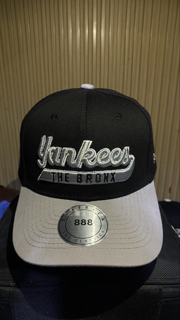 New York Yankees The Bronx Snapback Cap (Category: Caps & Hats) located in Manila. Submitted by _kyndzgrt (Listing ID 1468682968, Image 3). Description: - Color: Black and grey - Design: Yankees text embroidery on the front with 'The Bronx' detail - Branding: Classic white NY logo stitched on the side - Brim: Grey flat brim complete with silver Snapback Classics sticker - Fit: Adjustable snapback closure at the back - Style: Clean and classic str