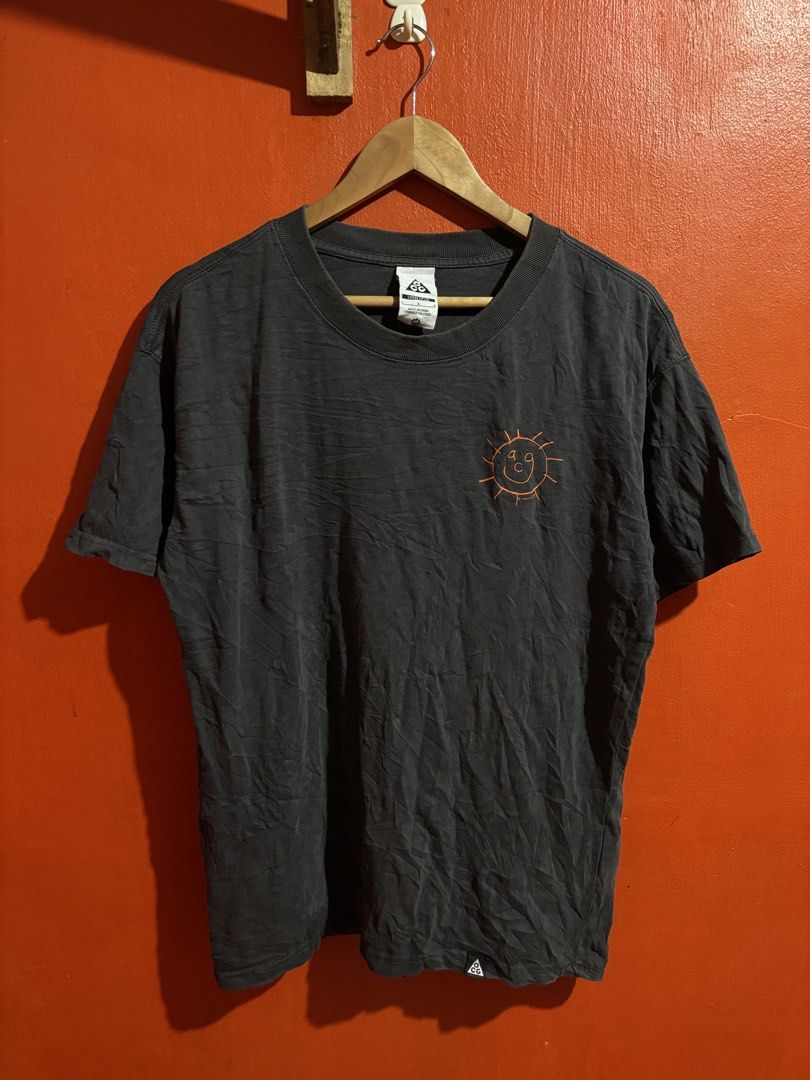 Nike ACG Sun Graphic Tee Dark Grey (Category: Tshirts & Polo Shirts ) located in Naga. Submitted by ajrc.shop (Listing ID 1468521130, Image 1). Description: Dark smoke grey Nike ACG Sunshine T-Shirt ✅Size: L ✅Width: 21.5 ✅Length: 27 ✅Color Rate: 9/10 ✅Issue: None ✅Need Wash ✅Location: Bicol Naga City, Camarines Sur ✅Courier: J&T Express/Flash Express ✅MOP: Gcash only.