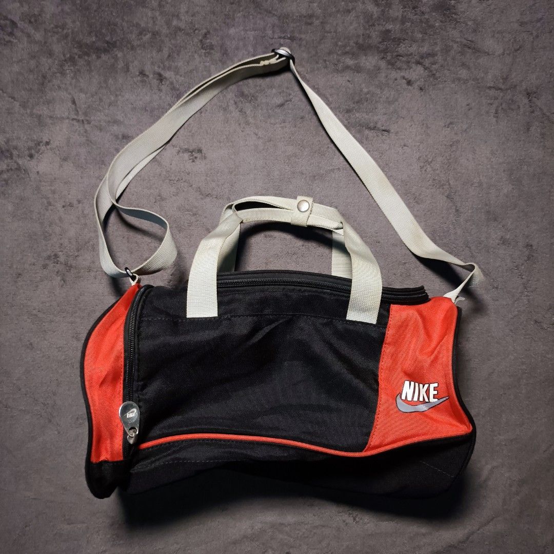 Nike Black and Red Mini Duffel Bag (Category: Sling Bags) located in Manila. Submitted by nye.seller (Listing ID 1468531821, Image 1). Description: - Brand: Nike - Color: Classic Black & Red - Style: Mini duffel bag (gym or travel) - Material: Durable polyester - Features: Adjustable shoulder strap, dual carry handles, and zip main compartment with clean interior - Design: Large Nike logo on the round side panel - Condition: Brand new / Excellent