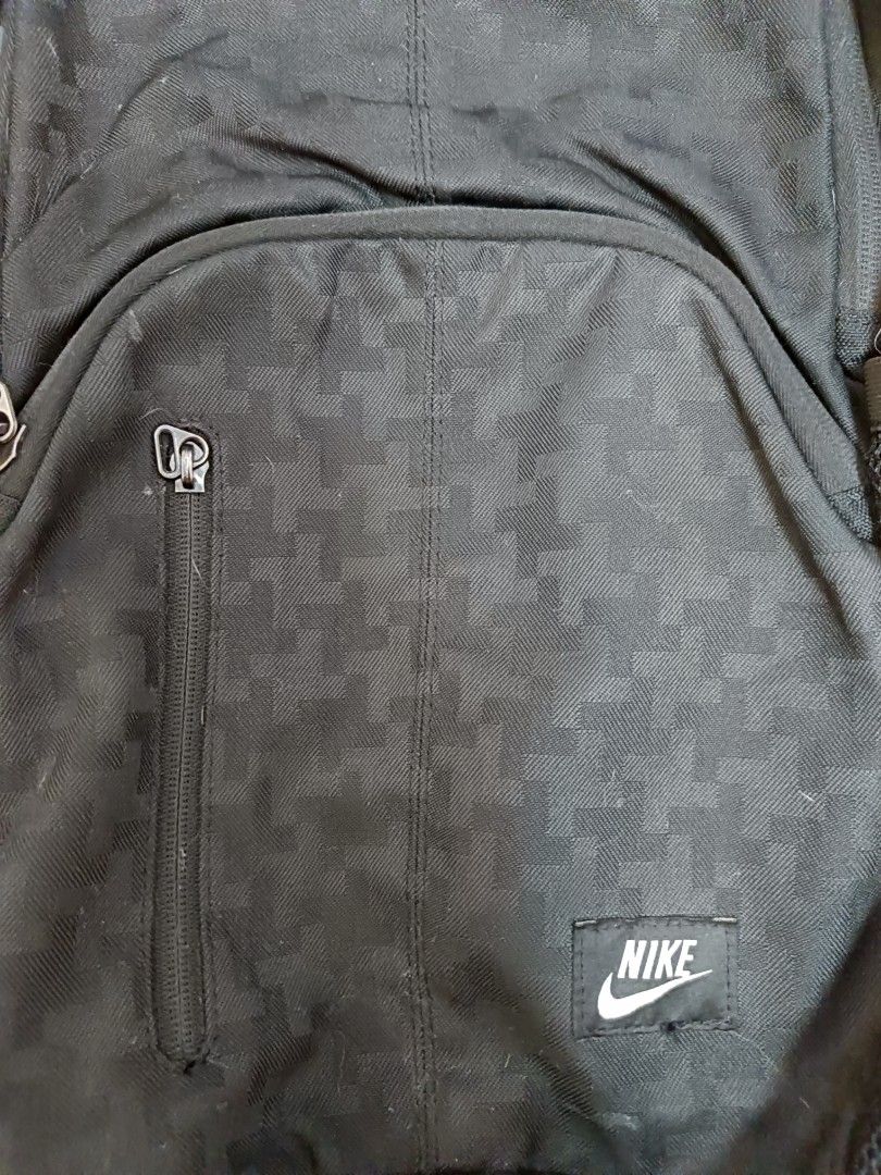 Nike Black Patterned Backpack (Category: Backpacks) located in Manila. Submitted by jaymarkmcacuyong (Listing ID 1468554425, Image 3). Description: - Brand: Nike - Color: Classic Black with subtle pattern texture - Storage: Multiple compartments with spacious interior - Pockets: Front vertical zip pocket and dual mesh side pockets for water bottles - Comfort: Adjustable padded shoulder straps with Nike branding patch - Versatility: Ideal for scho