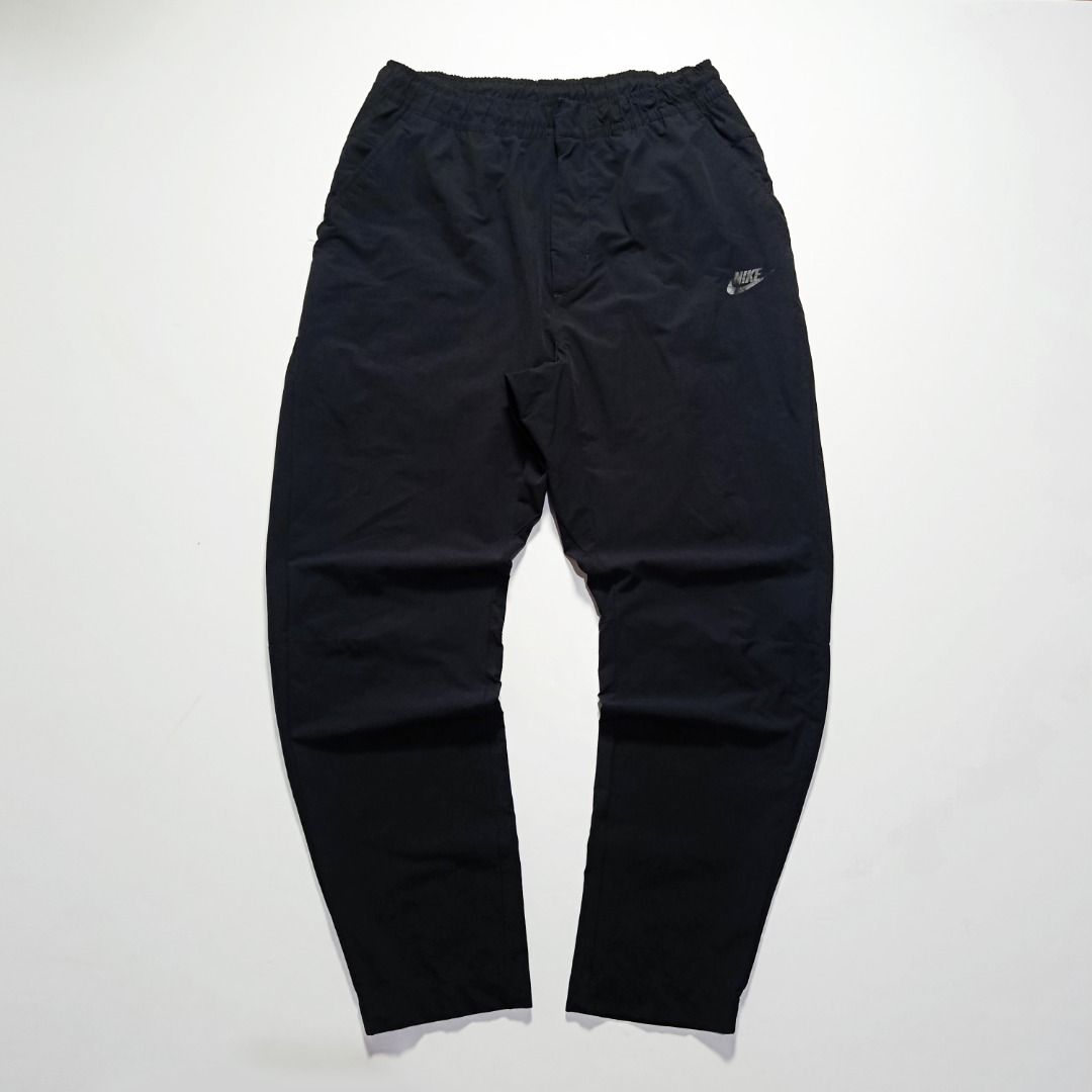 Nike Black Straight-Leg Woven Pants (Category: Joggers) located in Taytay. Submitted by hoodgrail.vtg (Listing ID 1468621225, Image 1). Description: • Excellent condition - Lightly used • Lightweight nylon-stretch fabric, subtle printed Swoosh logo and zippered side pocket • Size on tag: XL — best fits 28–32 • Measurements: 14.5 x 38.5 in • Leg opening: 5 in • Color rate: 9.5/10 • Issue: None.