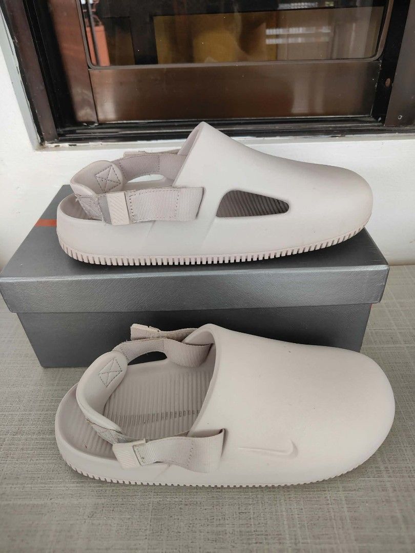 Nike Calm Slide Sandals Beige (Category: Slippers & Slides) located in Plaridel. Submitted by jkauthentics (Listing ID 1468536924, Image 3). Description: Used once❤️ - Brand: Nike Calm Slides - Color: Beige - Style: Slip-on with adjustable back strap and side cut-outs - Features: Embossed Nike swoosh, ribbed footbed, and textured sole for grip - Condition: Like new with slight scuffs on the soles from trial only.