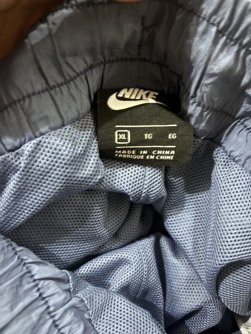 Nike Nylon Cargo Pants Blue XL (Category: Activewear) located in Quezon City. Submitted by juiriya (Listing ID 1468651459, Image 3). Description: - Brand: Nike - Item: Nylon cargo pants - Color: Navy blue with yellow and pink details - Size: XL - Features: Elastic waistband with speckled drawstring, mesh interior lining, deep side cargo pockets - Design: Matching yellow and multi-color paint splatter Nike logo on left pocket - Fit: Lightweight an
