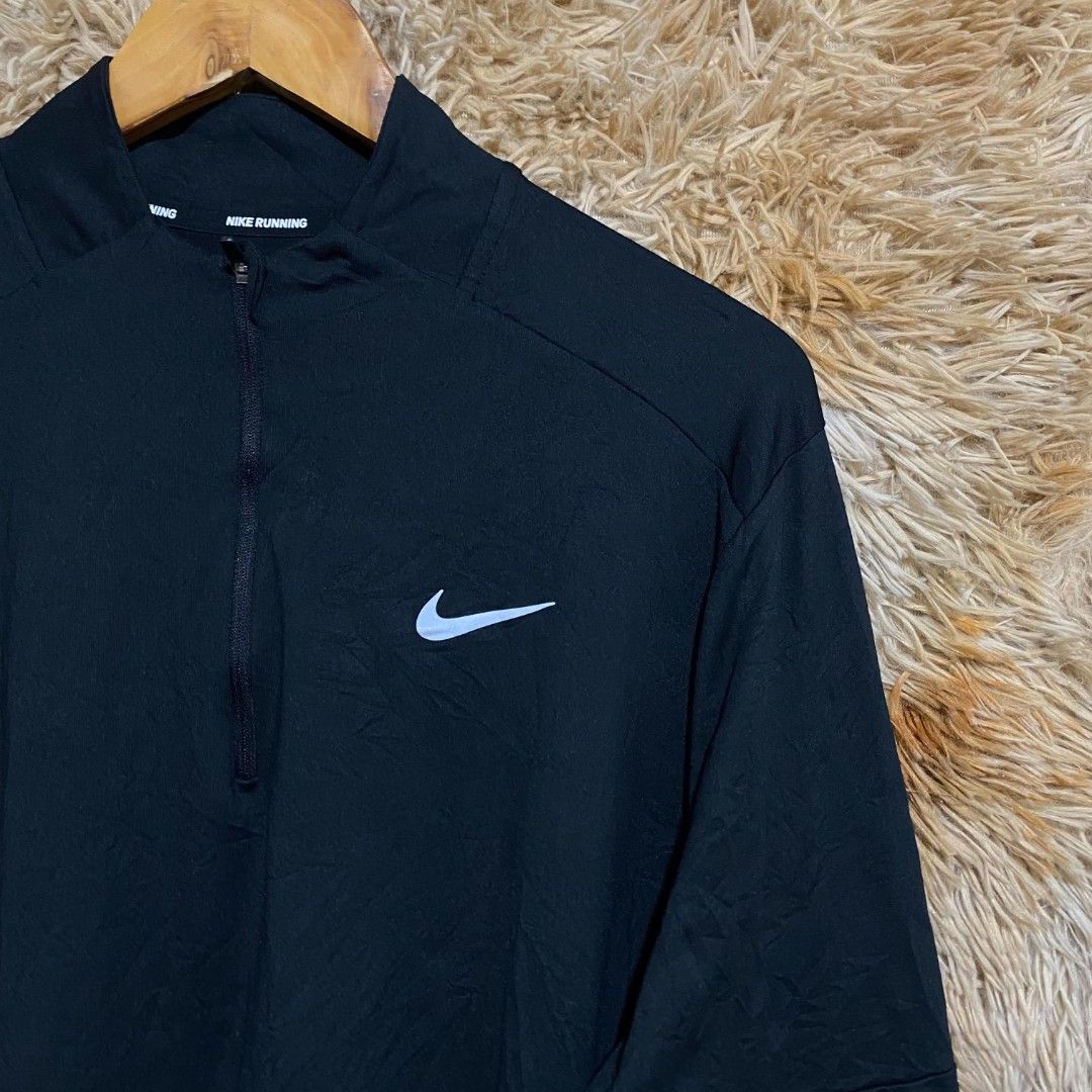 Nike Running Black 1/4 Zip Pullover Jacket (Category: Activewear) located in Butuan. Submitted by jcuabs041302 (Listing ID 1468669284, Image 2). Description: - Brand: Nike - Color: Classic Black - Style: Quarter-zip running pullover with high collar - Details: Iconic white swoosh logo on chest, 'Nike Running' text on inner neckline - Features: Lightweight workout fabric, long sleeves with thumbholes.
