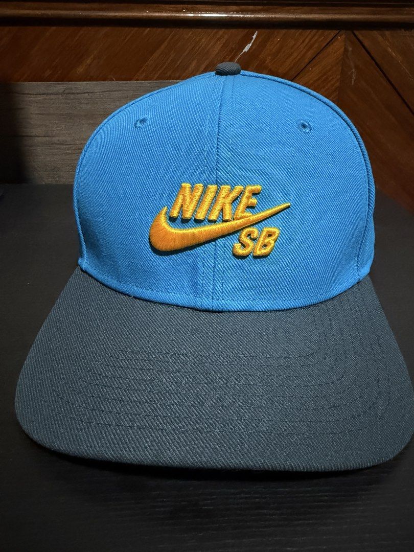 Nike SB Snapback Cap (Category: Caps & Hats) located in Manila. Submitted by db_collective (Listing ID 1468505047, Image 1). Description: - Authentic Nike SB snapback cap - Colorway: Light blue front panels with grey brim and back strap - Design: Yellow embroidered Nike SB logo on the front - Fit: Adjustable plastic snap closure with mini Nike SB tag - Details: Inner taping with repeated Nike SB branding - Condition: Excellent, unused.
