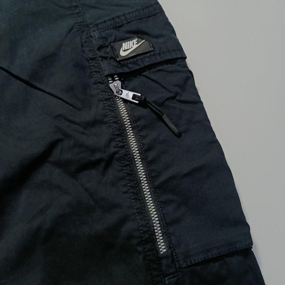 Nike Woven Cargo Pants with Zip Side Pocket (Category: Chinos) located in Taytay. Submitted by hoodgrail.vtg (Listing ID 1468623151, Image 3). Description: • Excellent condition - Like new • Black woven cargo pants featuring a zippered side pocket, utility cargo pockets, and Nike logo detailing • Size on tag: — best fits W32–34 (estimated; elastic waist) • Measurements: 16.5 x 39 in • Leg opening: 6.5 in • Color rate: 10/10 • Issue: Damaged edges