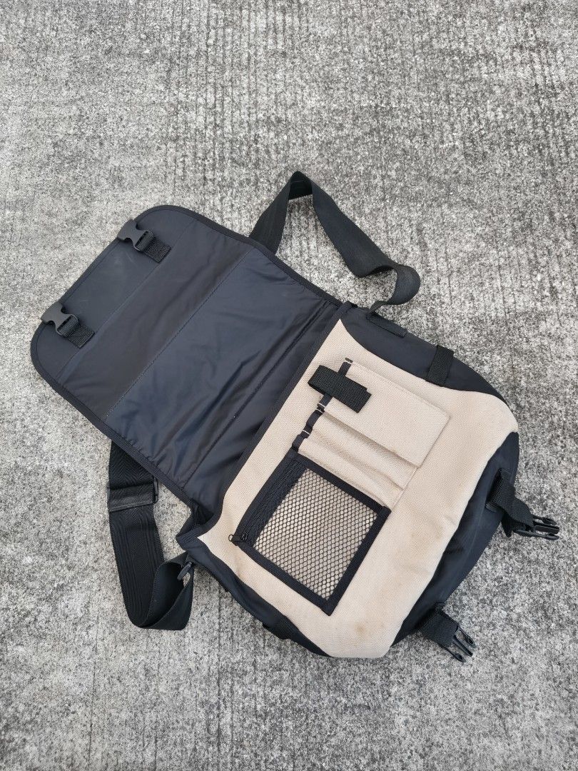 Nikon Messenger Camera Bag Tan Black (Category: Camera Bags & Carriers) located in Binan City. Submitted by makinpeso0622 (Listing ID 1468595524, Image 2). Description: - Brand: Nikon messenger bag - Color: Beige and black - Material: Durable canvas and nylon - Features: Adjustable shoulder strap, front flap with dual buckle closure - Interior: Padded main compartment with dividers, pen slots, and zippered mesh pocket - Exterior: Back slip pocket