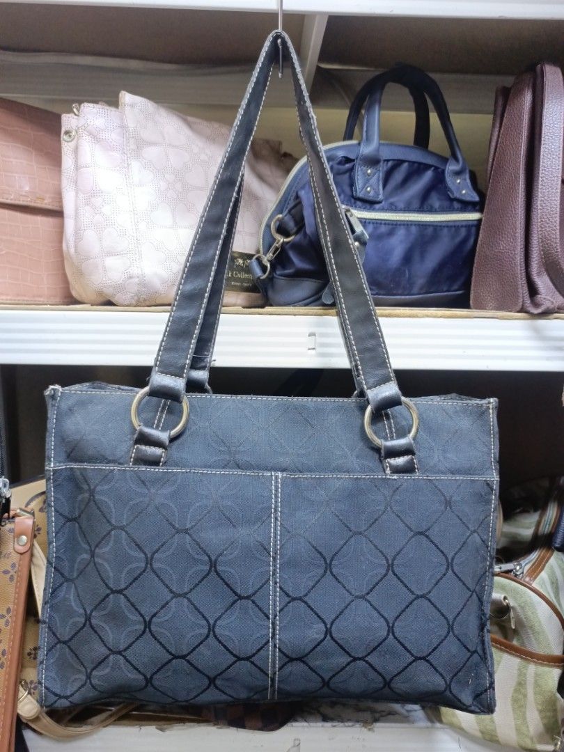 Nine West dark blue patterned tote handbag (Category: Tote Bags) located in Manila. Submitted by del_thrifts03 (Listing ID 1468669669, Image 2). Description: - Brand: Nine West - Color: Dark blue with geometric pattern and black accents - Material: Durable PVC fabric with black fabric lining - Straps: Comfortable black shoulder straps attached with stylish metal rings - Pockets: Convenient front slip pocket with metallic brand plate, plus interio