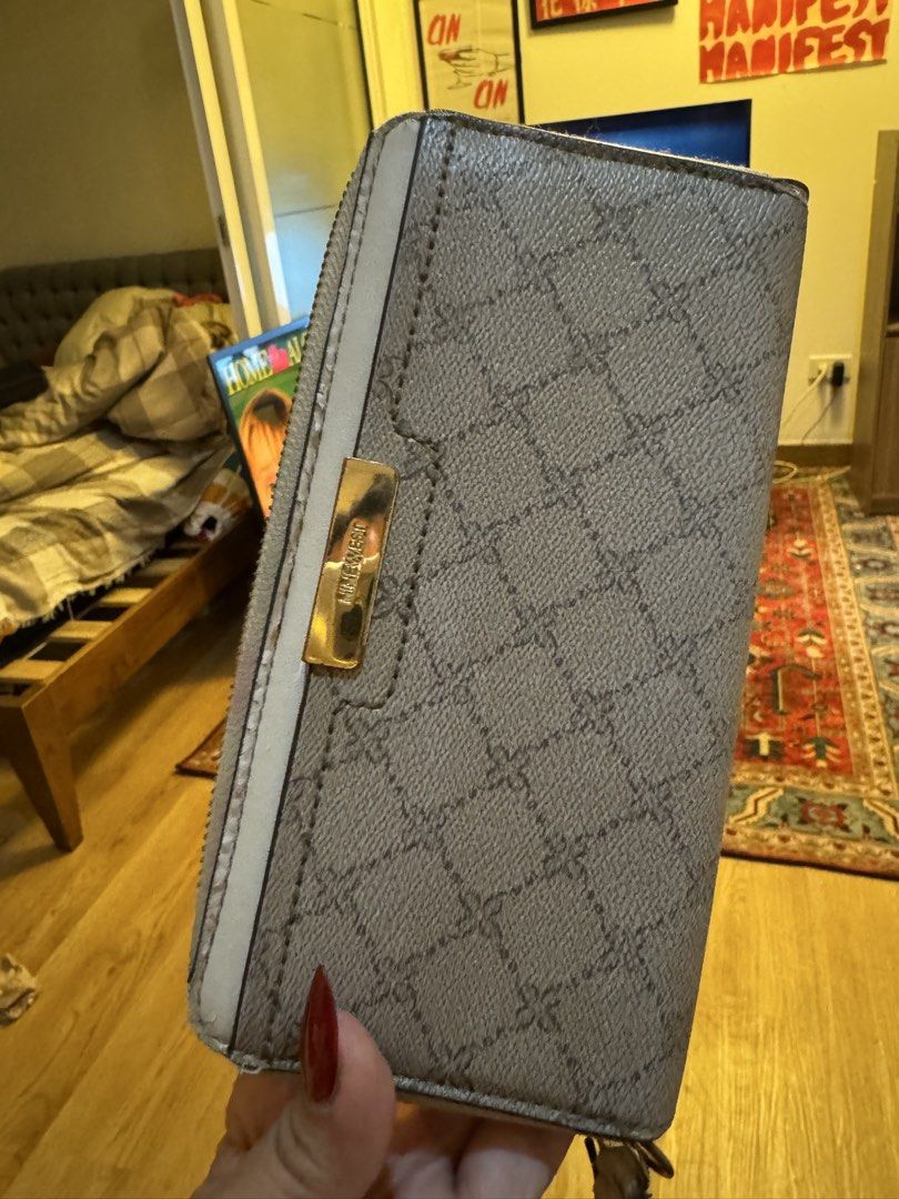 Nine West Monogram Pattern Zip Around Wallet Grey (Category: Wallets & Card holders) located in Mandaluyong City. Submitted by nicxannc (Listing ID 1468599508, Image 1). Description: - Brand: Nine West - Color: Grey with chic white piping - Design: All-over monogram pattern with gold-toned metal logo plate - Closure: Secure zip-around with zip pull - Interior: Spacious compartments for cards and cash - Condition: Clean and well-maintained.