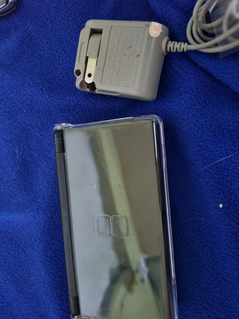 Nintendo DS Lite Black Handheld Console with Charger (Category: Nintendo) located in Angeles City. Submitted by roshangaming (Listing ID 1468569009, Image 1). Description: - Color: Classic Black - Condition: Fully working dual screens, clean buttons, and responsive d-pad - Inclusions: Original AC wall adapter charger and attached clear protective shell case - Authenticity: Serial number clearly readable on the back sticker - Ready-to-play portabl