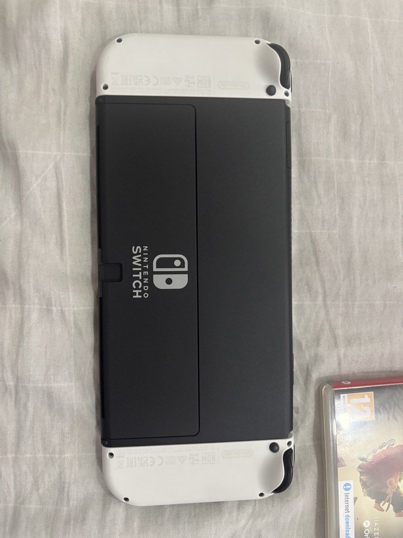 Nintendo Switch OLED White Console with Games and Case (Category: Nintendo) located in Floridablanca. Submitted by jmvbautista (Listing ID 1468543596, Image 3). Description: - Nintendo Switch OLED Model (White) in excellent, fully functional condition - Includes original box, TV dock, Joy-Con controllers, straps, and grip - Physical games included: The Legend of Zelda: Tears of the Kingdom and It Takes Two - Accessories included: Zelda-themed car