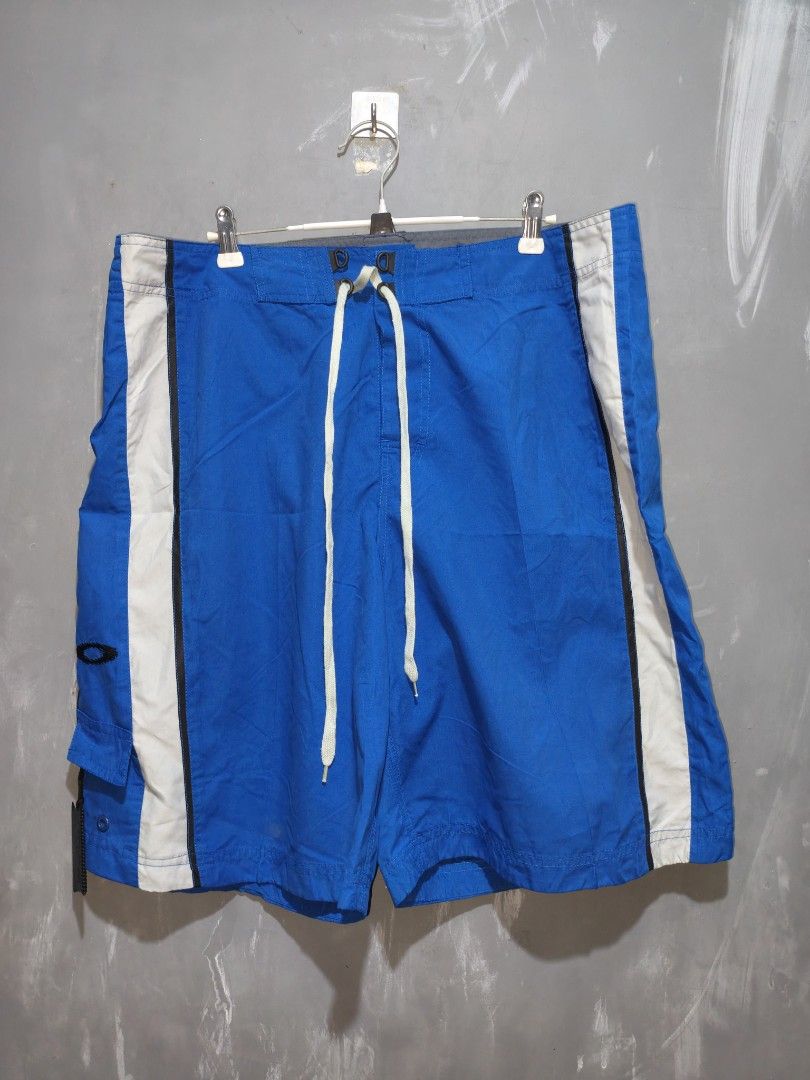 Oakley Blue White Board Shorts (Category: Swim Trunks & Board Shorts) located in Taguig. Submitted by daily_hustle (Listing ID 1468524946, Image 1). Description: - Brand: Oakley - Color: Bright blue with white side panels and black piping - Waist: Drawstring with branded eyelets - Pockets: Side cargo pocket featuring an embroidered Oakley icon - Details: Plastic Oakley-branded tag and curved grey back accent panel - Condition: Vibrant colors, sol