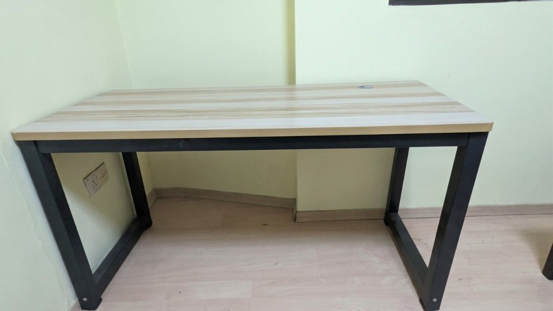 office/work/study table (Category: Tables & Sets) located in Singapore. Submitted by sleepy-panda (Listing ID 1468626765, Image 1). Description: Wooden top desk with sturdy black metal legs. Good for Study or office. Dimension - 140L * 60W * 75H Includes a built-in cable management grommet hole on the top right surface. Neutral light wood grain finish matches most room decors. Sturdy build, clean lines. Good size for studying, working from home, 