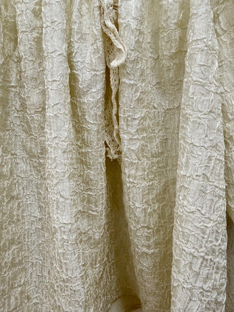 Off-shoulder cream textured blouse with lace trim (Category: Blouses) located in Manila. Submitted by chi.declutter (Listing ID 1468525594, Image 3). Description: - Color: Cream - Style: Off-shoulder top with puffy half sleeves - Details: Textured crinkle fabric, white floral lace trim, and center front tie with lace ribbon - Fit: Loose and breezy - Versatility: Easy to dress up with a skirt or keep casual with denim - Condition: Brand new / Exce