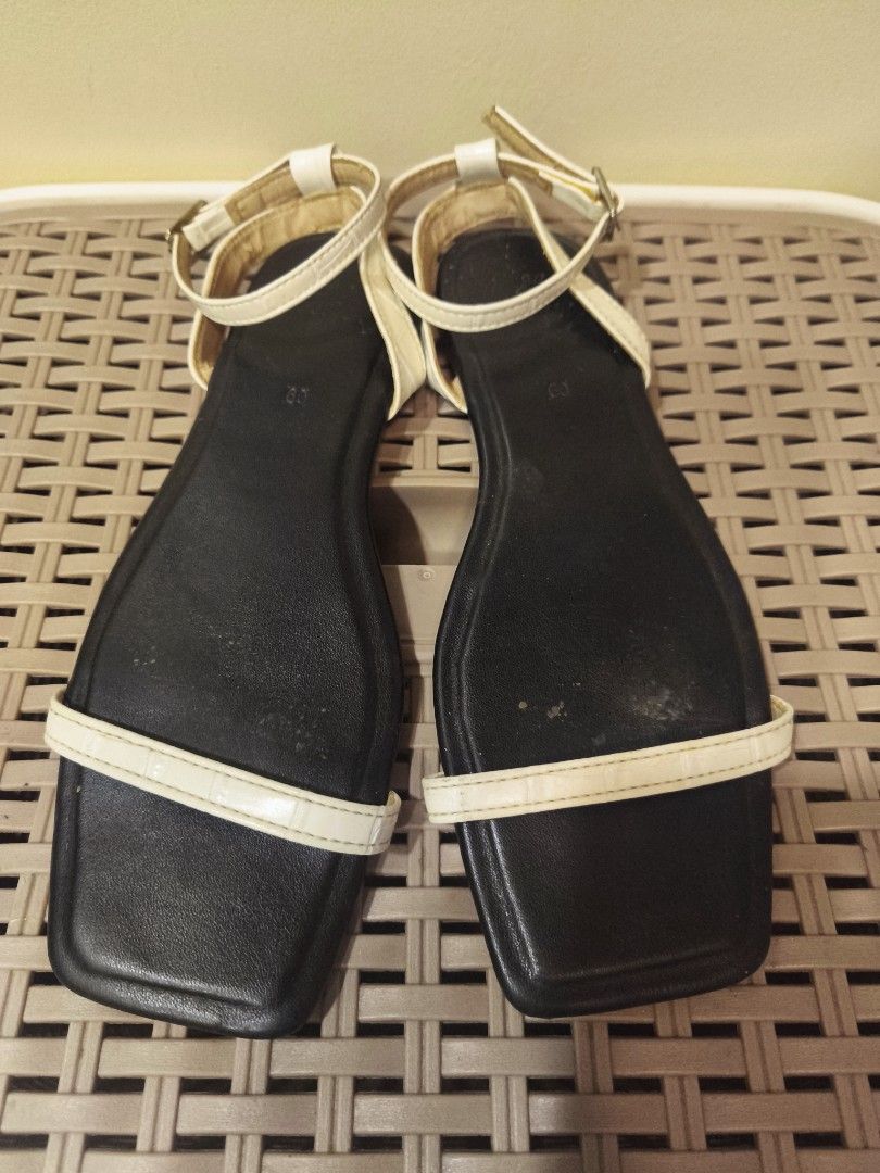 Olivia White and black flat sandals with ankle strap (Category: Flats & Sandals) located in Baguio. Submitted by zia_zab (Listing ID 1468530700, Image 2). Description: - Color: Classic black with a contrast white front strap - Design: Trendy square toe with secure ankle strap and buckle closure - Style: Simple, versatile flat sandals perfect for everyday casual outfits - Condition: Pre-loved with visible signs of wear and dirt on the soles - Budg