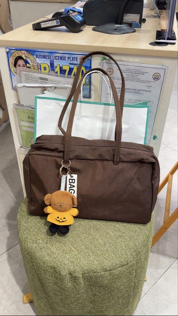 Original Baggu Medium Nylon Bowler Bag Coffee (Category: Tote Bags) located in Antipolo. Submitted by xpepayx (Listing ID 1468527994, Image 1). Description: Actual and own pictures posted Original Baggu Bowler Bag - MEDIUM SIZE **Charms and contents not included Bought from Certified Calm Podium Spacious, water resistant Lightweight, perfect pang everyday Kasya 14inch laptop! RFS: too many bags, decluttering Location: Antipolo near simbahan Lalam