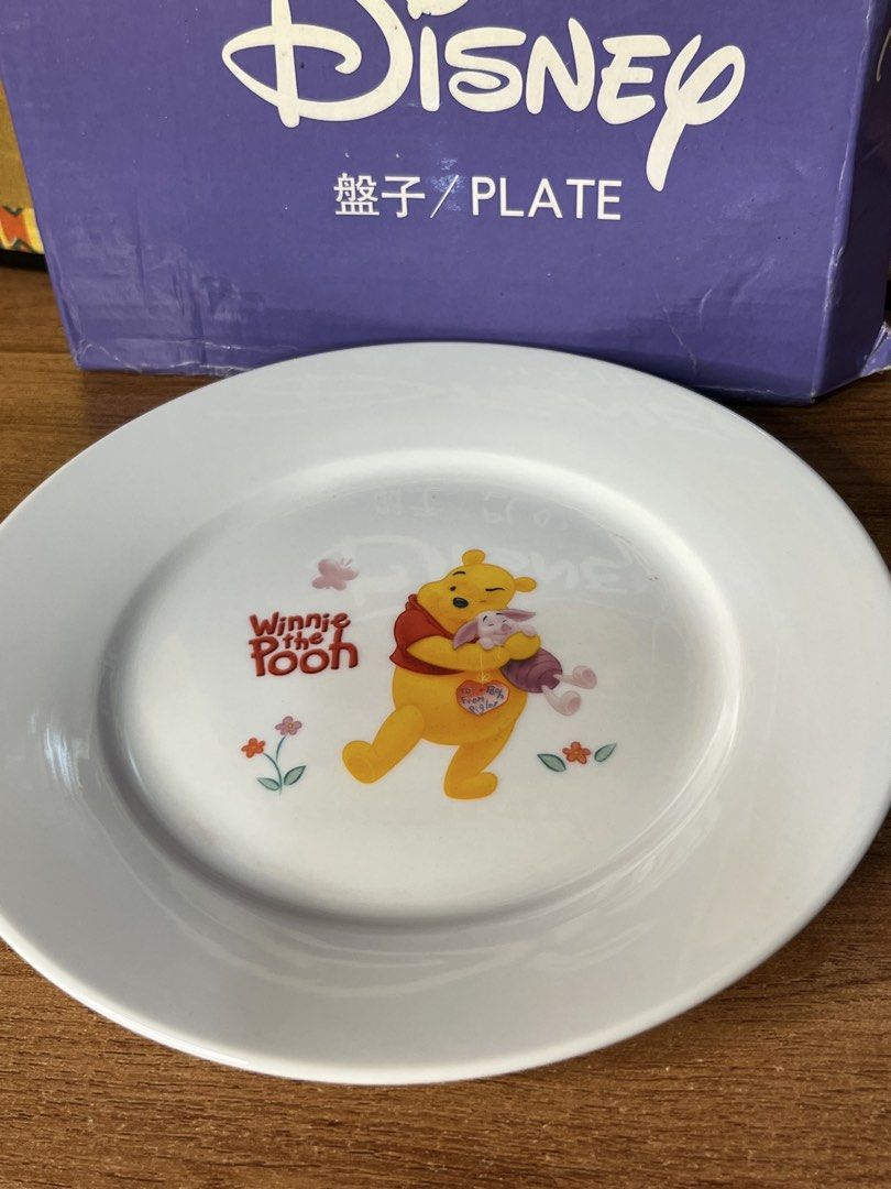 Original Disney Winnie the Pooh Plate with Box (Category: Dinnerware & Cutlery) located in Gapan. Submitted by lunashop14 (Listing ID 1468692421, Image 2). Description: - Official Disney merchandise by Way Link, based on A.A. Milne and E.H. Shepard works - Features a charming illustration of Winnie the Pooh hugging Piglet with flowers and a butterfly - Brand new and never used, in pristine condition - Comes complete with the original purple Disne
