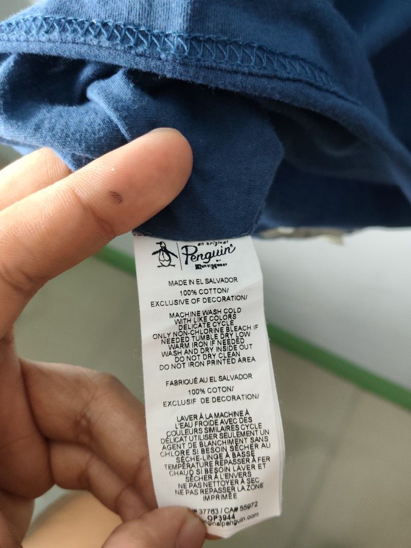 Original Penguin Blue Graphic Tee (Category: Tshirts & Polo Shirts ) located in Quezon City. Submitted by needforthrift (Listing ID 1468636273, Image 3). Description: - Brand: Original Penguin by Munsingwear - Size: Small (S) - Color: Blue - dimension: 18 width 27.5 length - Material: 100% cotton (super soft) - Fit: Standard fit with short sleeves - Design: Large penguin graphic on chest - Care: Machine washable - Origin: Made in El Salvador.