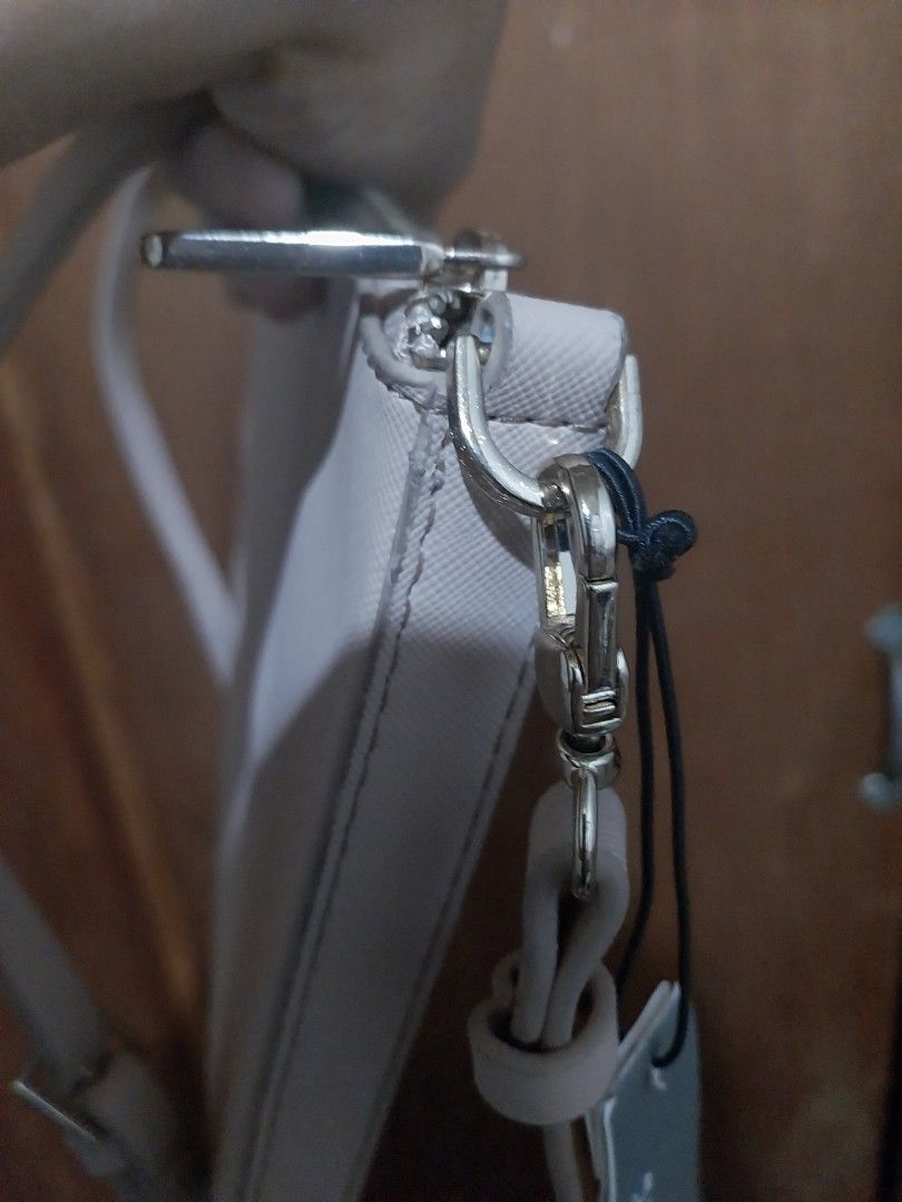 Parfois Crossbody Bag Beige (Category: Cross-body Bags) located in Manila. Submitted by j.dlh (Listing ID 1468667185, Image 3). Description: - Brand: Parfois - Color: Beige - Material: Faux leather with Saffiano texture - Condition: Like new with original tag - Hardware: Gold-tone (no fade) - Closure: Zip closure - Pockets: Front slip pocket and interior zippered pocket - Lining: Black fabric - Strap: Detachable matching strap included - Issue so