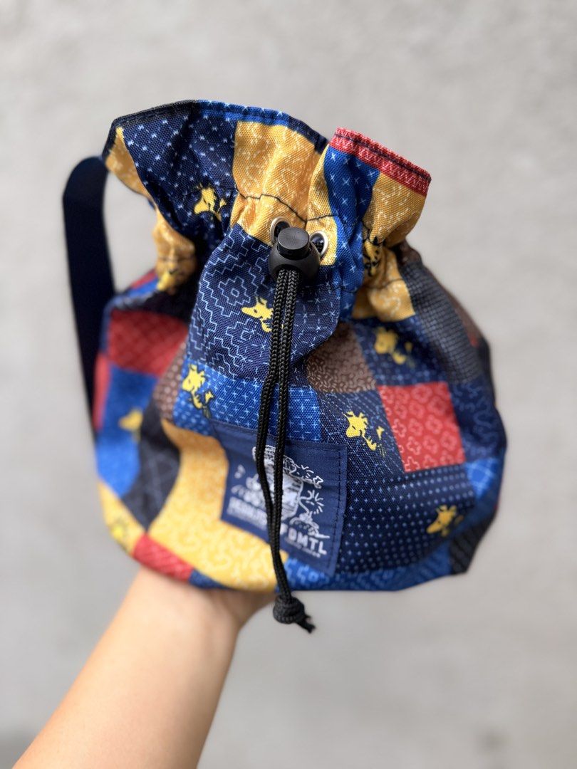 PEANUTS for FDMTL Tokyo Japan Patchwork Drawstring Bag (Category: Shoulder Bags) located in Baguio. Submitted by aalkharys (Listing ID 1468676163, Image 2). Description: - Authentic PEANUTS x FDMTL Tokyo collaboration - Eye-catching blue, yellow, and red patchwork design - Features iconic Snoopy and Woodstock graphics - Secure drawstring closure with an adjustable toggle - Dark blue shoulder strap and matching interior lining - Branded woven patc