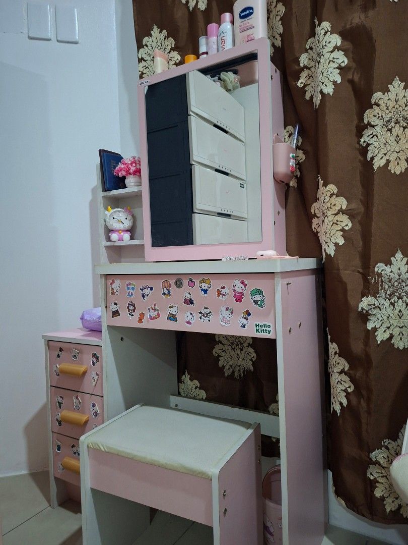 Pink Hello Kitty Vanity Table Set with Stool (Category: Home Improvement Tools & Accessories) located in Manila. Submitted by eayya (Listing ID 1468606317, Image 1). Description: - Complete set: Pink vanity desk with a matching padded stool - Decorated with cute Kitty stickers - Ample storage: Shelves, pull-out drawers, and a sliding mirror cabinet - Ideal for organizing makeup and skincare essentials - Durable and sturdy wooden construction.