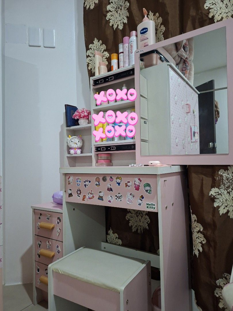 Pink Hello Kitty Vanity Table Set with Stool (Category: Home Improvement Tools & Accessories) located in Manila. Submitted by eayya (Listing ID 1468606317, Image 2). Description: - Complete set: Pink vanity desk with a matching padded stool - Decorated with cute Kitty stickers - Ample storage: Shelves, pull-out drawers, and a sliding mirror cabinet - Ideal for organizing makeup and skincare essentials - Durable and sturdy wooden construction.