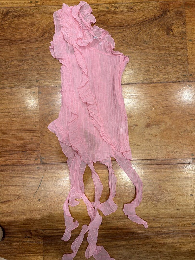 Pink Ruffle Asymmetrical Top With Long Ties (Category: Sleeveless) located in Quezon City. Submitted by nic.man (Listing ID 1468642358, Image 1). Description: - Color: Light pink - Style: One-shoulder asymmetrical top - Details: Pleated fabric, ruffled front trim, and hanging ribbon straps at the hem - Material: Sheer, lightweight - Perfect for: Going out dates and night outs.