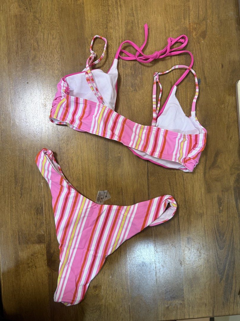 Pink Striped Two-Piece Bikini (Category: Bikinis & Swimsuits) located in Makati City. Submitted by shoprory (Listing ID 1468596782, Image 2). Description: - Pink striped bikini set with vibrant multi-colored vertical stripes (pink, orange, yellow, white) - Triangle top with adjustable halter ties and secure back closure - Matching high-cut bottoms for a flattering silhouette - Fully lined interior for comfort and coverage - Brand new with standar