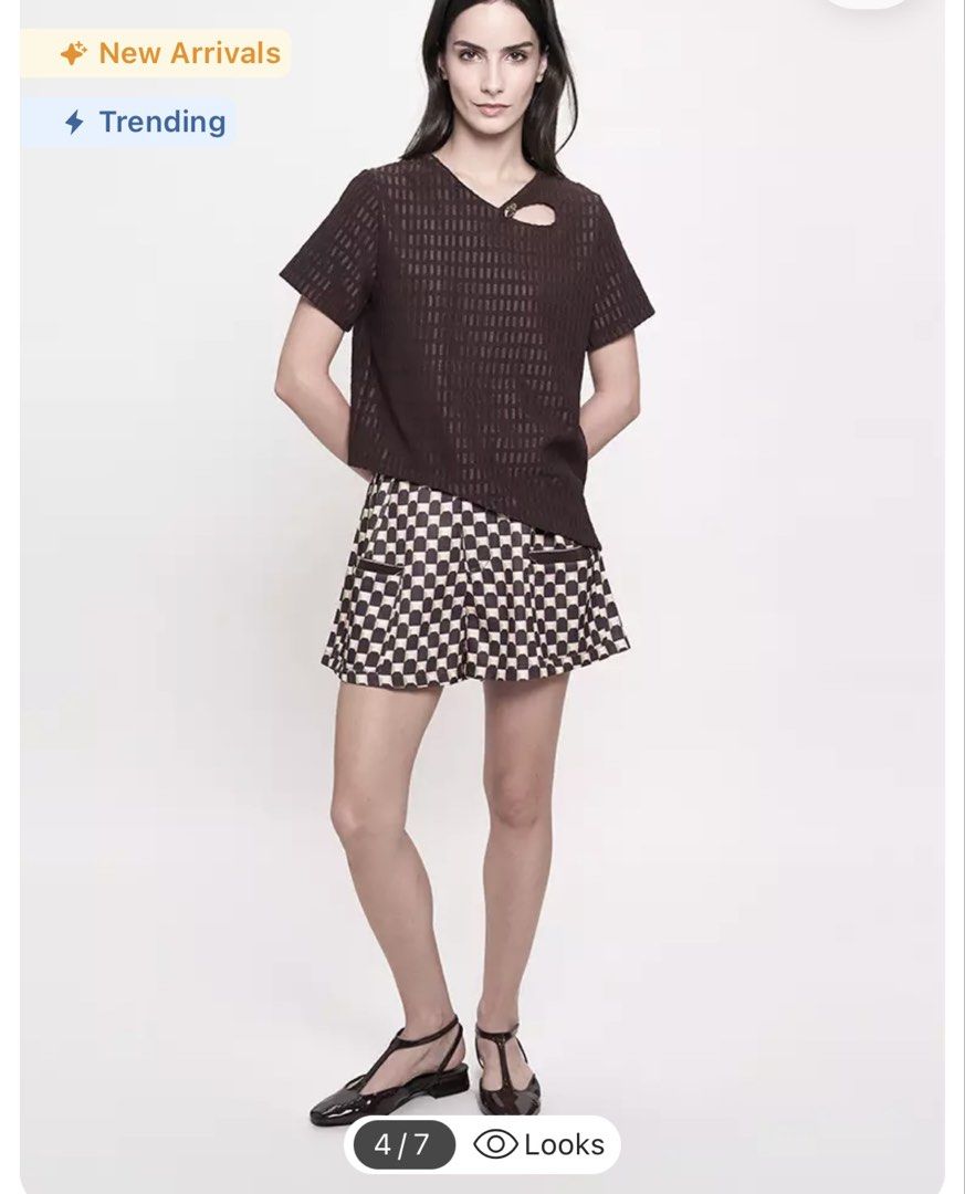 Plains & Prints Brown Short Sleeve Top (Category: Blouses) located in Iba. Submitted by geliqq (Listing ID 1468657981, Image 3). Description: - Brand: Plains & Prints - Color: Dark Brown - Style: Short sleeve blouse with relaxed fit - Details: Textured grid pattern, unique neckline cutout with a gold-tone accent button, and trendy asymmetrical hem - Versatility: Easy to dress up for work or down for casual days - Condition: Excellent pre-loved co