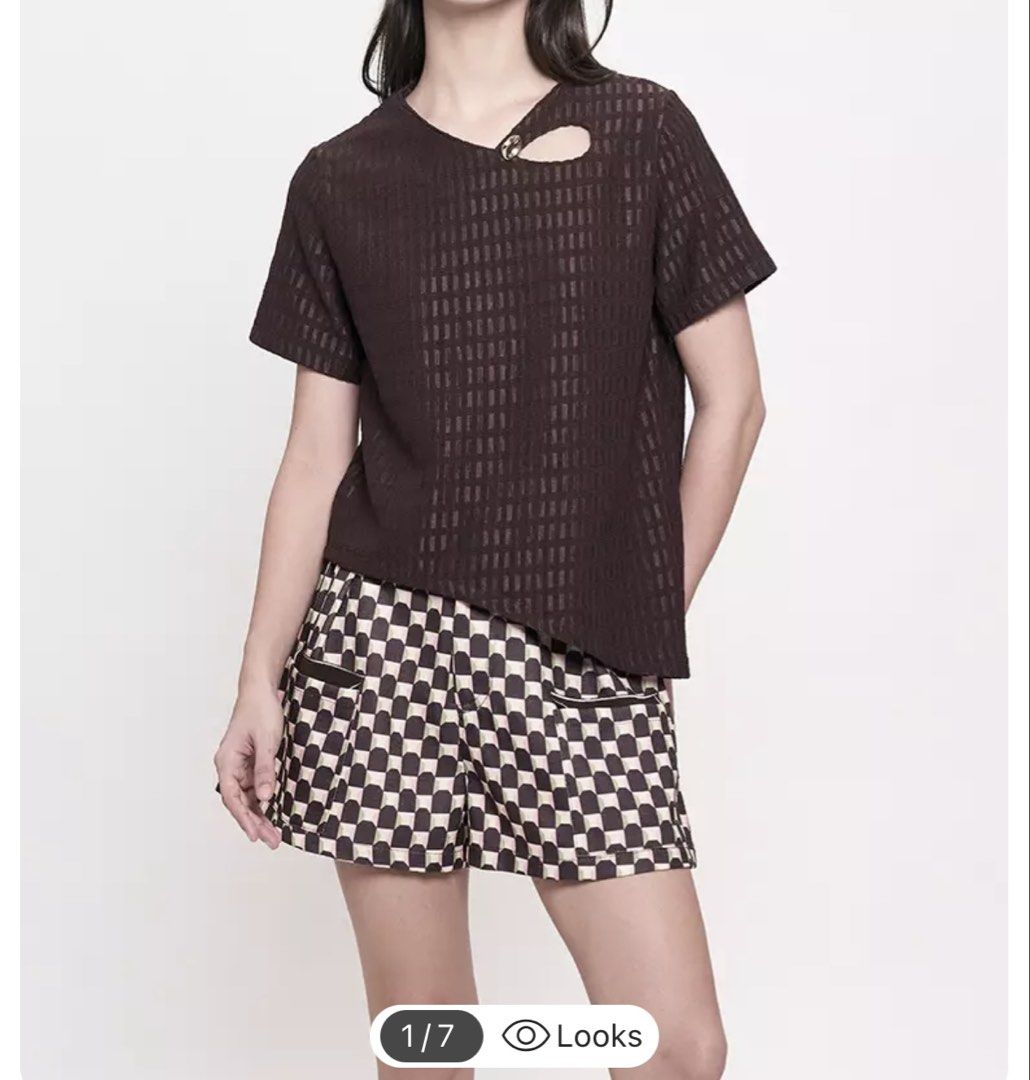 Plains & Prints Brown Short Sleeve Top (Category: Blouses) located in Iba. Submitted by geliqq (Listing ID 1468657981, Image 1). Description: - Brand: Plains & Prints - Color: Dark Brown - Style: Short sleeve blouse with relaxed fit - Details: Textured grid pattern, unique neckline cutout with a gold-tone accent button, and trendy asymmetrical hem - Versatility: Easy to dress up for work or down for casual days - Condition: Excellent pre-loved co
