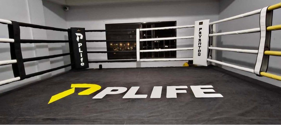 PLIFE Professional Boxing Ring with Padded Ropes (Category: Combat Sports) located in Pasig City. Submitted by rhi-stock (Listing ID 1468574912, Image 1). Description: - Brand: PLIFE professional boxing ring setup - Flooring: Heavy-duty black canvas with large yellow and white center branding - Inclusions: Sturdy corner pads and multi-colored ropes (white, black, yellow) - Ideal for: Gyms, training facilities, and martial arts studios - Note: Buy