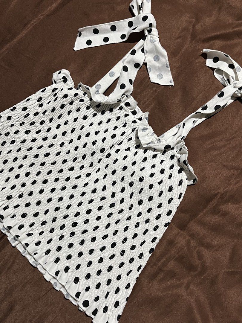 Polka Self Tie Smocked Top Size S (Category: Blouses) located in Manila. Submitted by maaya.rikit (Listing ID 1468621317, Image 2). Description: - Color/Pattern: White with all-over black polka dots - Size: S - Fit/Details: Smocked elastic body with ruffled trim at the top and bottom - Straps: Self-tie ribbon shoulder straps - Versatility: Great basic for sunny days or layering under jackets.