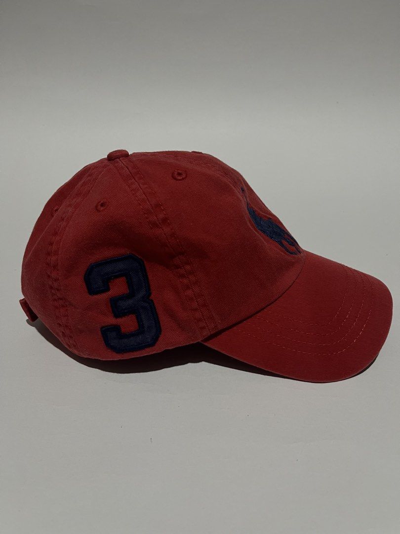 Polo Ralph Lauren Red Cap Number 3 (Category: Caps & Hats) located in Dumangas. Submitted by chiiieeef (Listing ID 1468712246, Image 3). Description: - Brand: Polo Ralph Lauren - Color: Vibrant red with dark blue embroidered pony and number 3 patch - Material: 100% cotton for a comfortable fit - Details: Embroidered "POLO" text on the back and adjustable metal buckle closure - Size: One size (Youth 8-20 / 56cm circumference) - Condition: Excellen