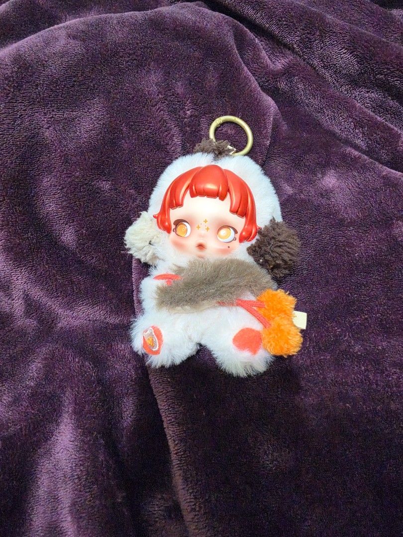 Pop Mart Skullpanda Plush Keychain Doll (Category: Plushies & Soft Toys) located in Pasig City. Submitted by cheribomb85 (Listing ID 1468711106, Image 1). Description: - Fluffy plush keychain with a soft white furry body and cute orange accents - Features stunning glossy red hair and detailed golden eyes - Comes with a sturdy gold-tone keyring loop for easy hanging - Compact size, perfect for bags, backpacks, or keys - Clean condition and super s