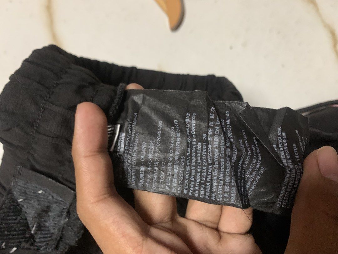Prada Black Nylon Cargo Shorts (Category: Shorts) located in Iloilo. Submitted by johnpullan30303 (Listing ID 1468682539, Image 2). Description: - Brand: Prada - Color: Black - Material: Sustainable recycled Econyl nylon - Fit: Elastic waistband with adjustable drawstring closure - Details: Side cargo pocket featuring the iconic metal triangle logo badge - Condition/Authenticity: Interior tags and brand label fully attached - Style: Lightweight, 