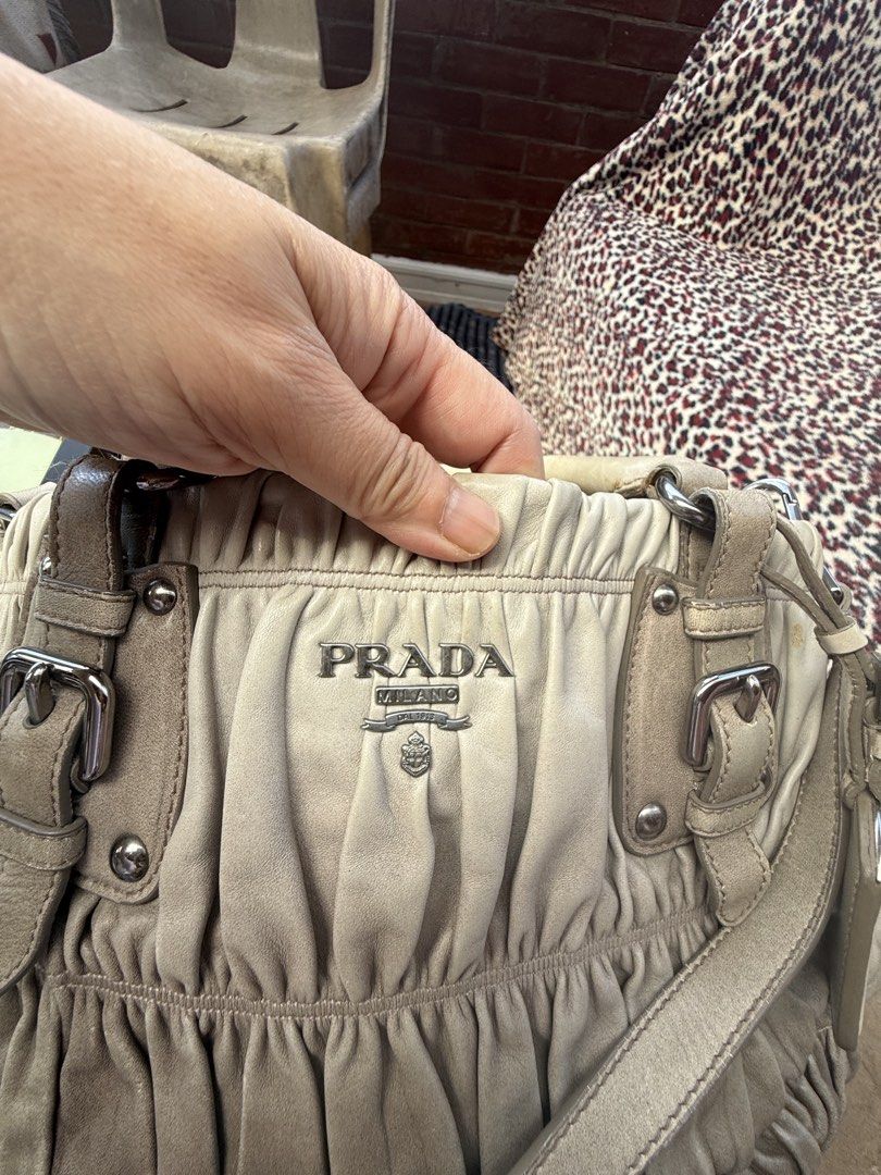 Prada Grey Leather Ruched Shoulder Bag (Category: Luxury Bags & Wallets) located in Baguio. Submitted by kasimngan1971 (Listing ID 1468518603, Image 3). Description: - Authentic Prada shoulder bag in versatile grey - Crafted from soft ruched leather with silver-tone hardware and buckle accents - Dual top handles plus a convenient detachable strap - Features the iconic Prada logo plaque on the front - Spacious fabric-lined interior with secure zip