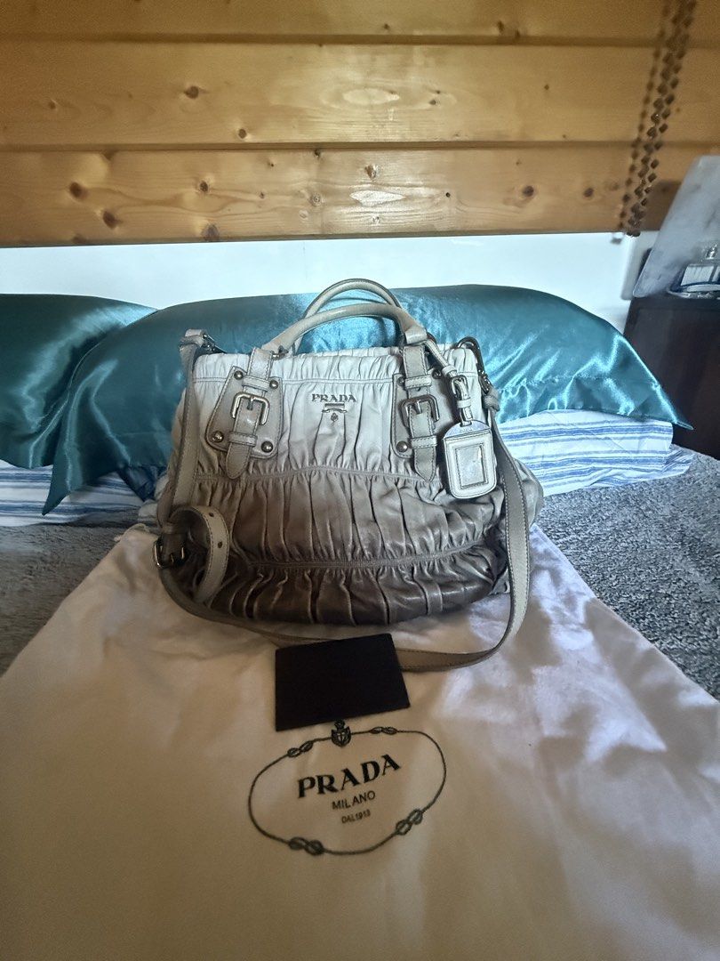 Prada Grey Leather Ruched Shoulder Bag (Category: Luxury Bags & Wallets) located in Baguio. Submitted by kasimngan1971 (Listing ID 1468518603, Image 2). Description: - Authentic Prada shoulder bag in versatile grey - Crafted from soft ruched leather with silver-tone hardware and buckle accents - Dual top handles plus a convenient detachable strap - Features the iconic Prada logo plaque on the front - Spacious fabric-lined interior with secure zip