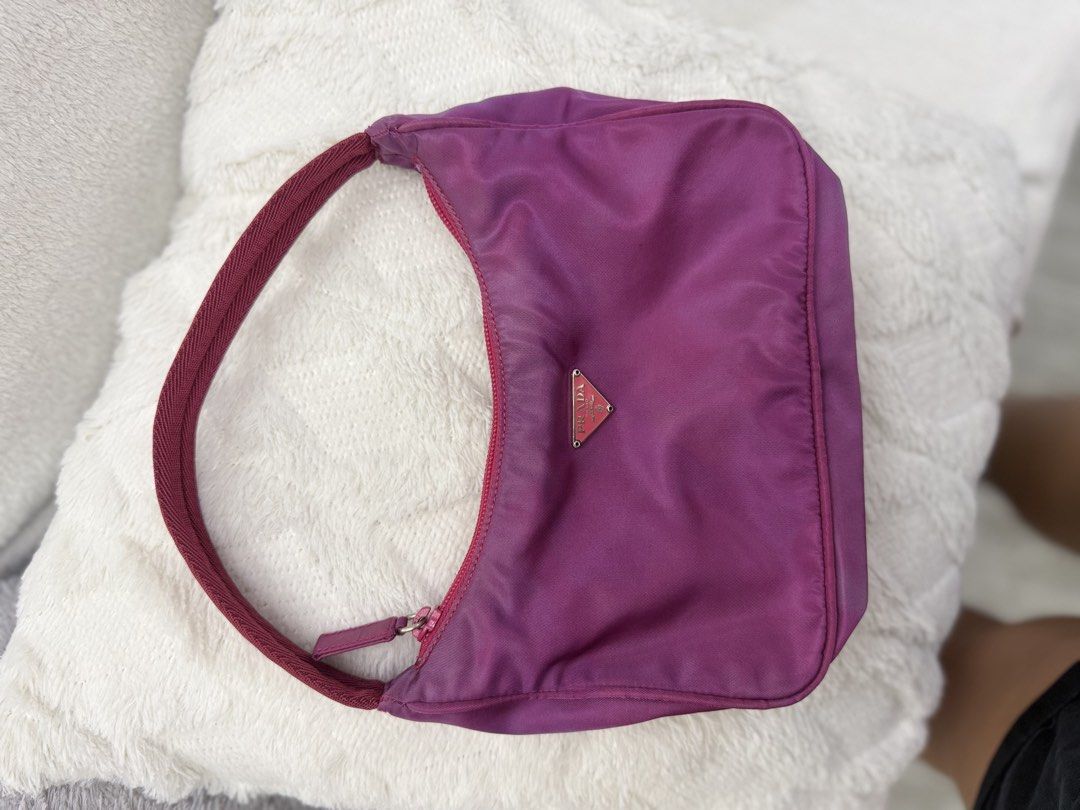 Prada Nylon re edition (Category: Luxury Bags & Wallets) located in Pasig City. Submitted by sherill888 (Listing ID 1468599536, Image 3). Description: - Authentic Prada nylon mini hobo bag in a stunning purple color - Eye-catching pinkish-red woven strap and matching zip closure - Silver-tone hardware and iconic triangular enamel logo plaque on the front - Clean fabric-lined interior featuring the classic 'Made in Italy' metal logo tag - Compact 