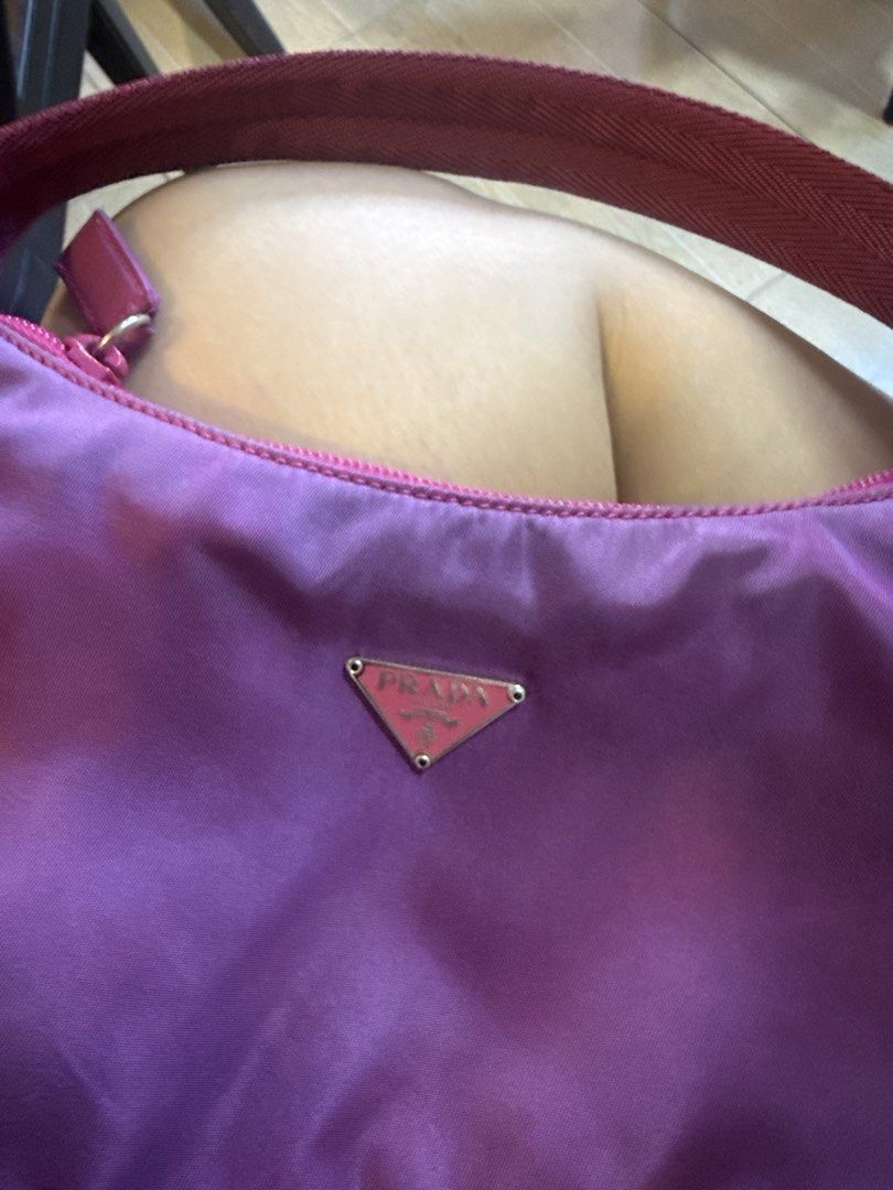 Prada Nylon re edition (Category: Luxury Bags & Wallets) located in Pasig City. Submitted by sherill888 (Listing ID 1468599536, Image 2). Description: - Authentic Prada nylon mini hobo bag in a stunning purple color - Eye-catching pinkish-red woven strap and matching zip closure - Silver-tone hardware and iconic triangular enamel logo plaque on the front - Clean fabric-lined interior featuring the classic 'Made in Italy' metal logo tag - Compact 