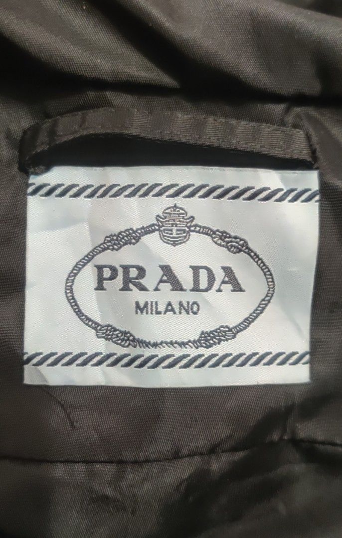 Prada Re Nylon Gabardine Jacket (Category: Coats, Jackets and Outerwear) located in Bago City. Submitted by louielinco (Listing ID 1468628040, Image 2). Description: - Brand: Prada - Item: Hooded Nylon Jacket - Size: Small On Tag Best Fit To Large Women's - Color: Classic Black - Details: Iconic triangular logo plaque on chest, dual front utility pockets, and adjustable waist drawstrings - Closure: Full front zip with snap buttons stamped with Pr