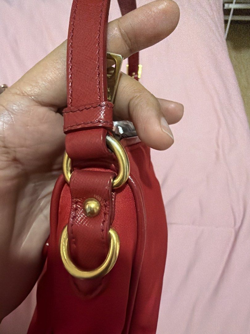 Prada Red Nylon Handbag with Gold Hardware (Category: Luxury Bags & Wallets) located in Rizal. Submitted by lee.avery (Listing ID 1468527559, Image 3). Description: - Authentic bright red Prada nylon handbag - Luxurious gold-tone hardware and zippers - Iconic enamel triangle logo plaque - Convenient front zip pocket with pull tab - Comfortable single strap design - Top zip closure (plastic wrapping still intact on some parts) - Clean corners and 