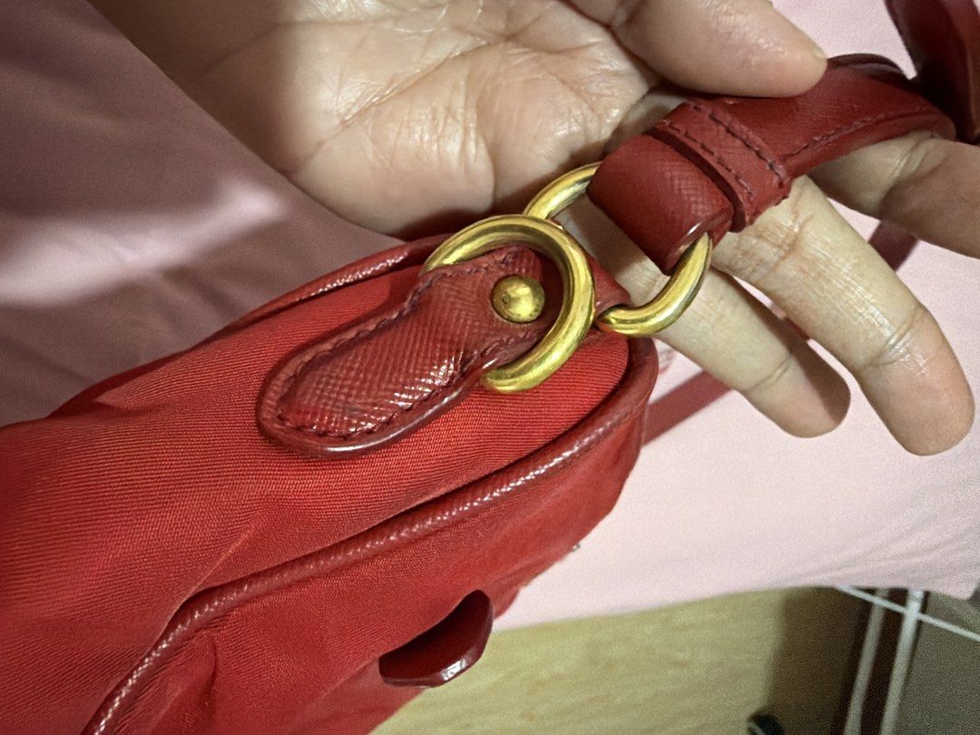 Prada Red Nylon Handbag with Gold Hardware (Category: Luxury Bags & Wallets) located in Rizal. Submitted by lee.avery (Listing ID 1468527559, Image 2). Description: - Authentic bright red Prada nylon handbag - Luxurious gold-tone hardware and zippers - Iconic enamel triangle logo plaque - Convenient front zip pocket with pull tab - Comfortable single strap design - Top zip closure (plastic wrapping still intact on some parts) - Clean corners and 