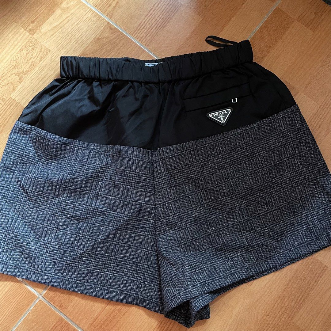 SOLDD Prada ReNylon and Wool Houndstooth Shorts (Category: Shorts) located in Santa Rosa. Submitted by jamrose (Listing ID 1468561952, Image 2). Description: L 14 W25-28 (Made in Romania) - Condition: with original tags attached - Design: Mixed-media style with black Re-Nylon upper and grey wool houndstooth tweed lower - Features: Comfortable elastic waistband, hip zip pocket, and signature enamel triangle logo plaque.