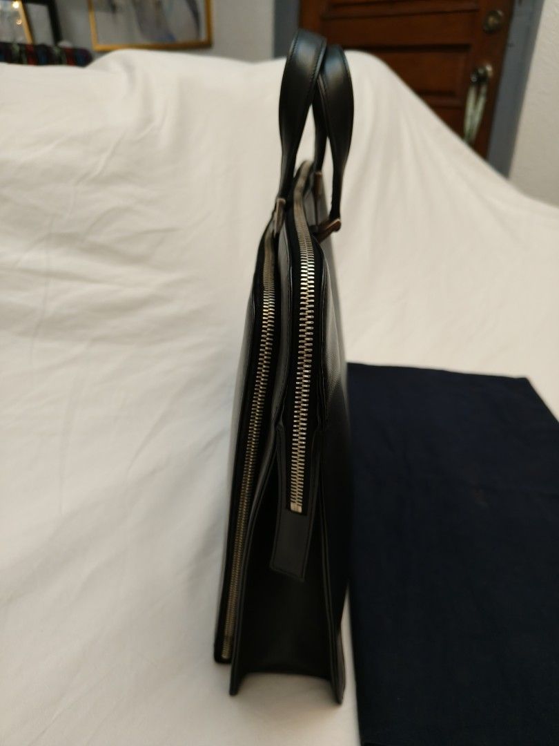 Prada Saffiano Leather Triangle Briefcase (Category: Luxury Bags & Wallets) located in Makati City. Submitted by emem.pre.owned.ph (Listing ID 1468547485, Image 3). Description: Brand: Prada -Model: Saffiano Leather Triangle Briefcase -Material: Saffiano leather -Hardware: Silver-coloured -Dimensions: 29 x 40 x 9.5 cm -Interior: Very good -Accessories: Authenticity card, dustbag -Carry style: Handbag.