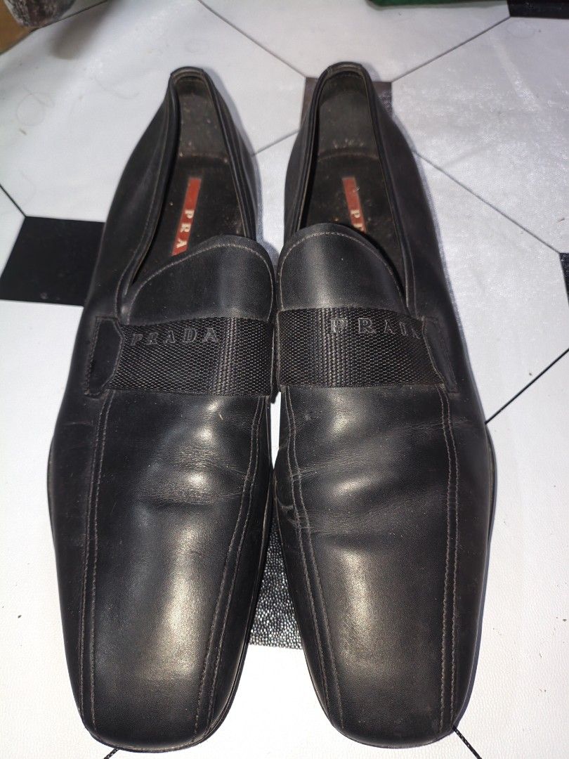 Prada Sport "Linea Rossa" (Category: Loafers) located in Quezon City. Submitted by reinellsai49218 (Listing ID 1468512956, Image 1). Description: - Brand: Prada - Style: Slip-on loafers with square toe - Color: Black - Material: Premium leather upper and inner lining - Details: Elastic strap band with stamped Prada lettering and iconic red logo tag inside the heel - Authenticity Code: 4D 1571 stamped inside - Condition: Regular signs of wear on t