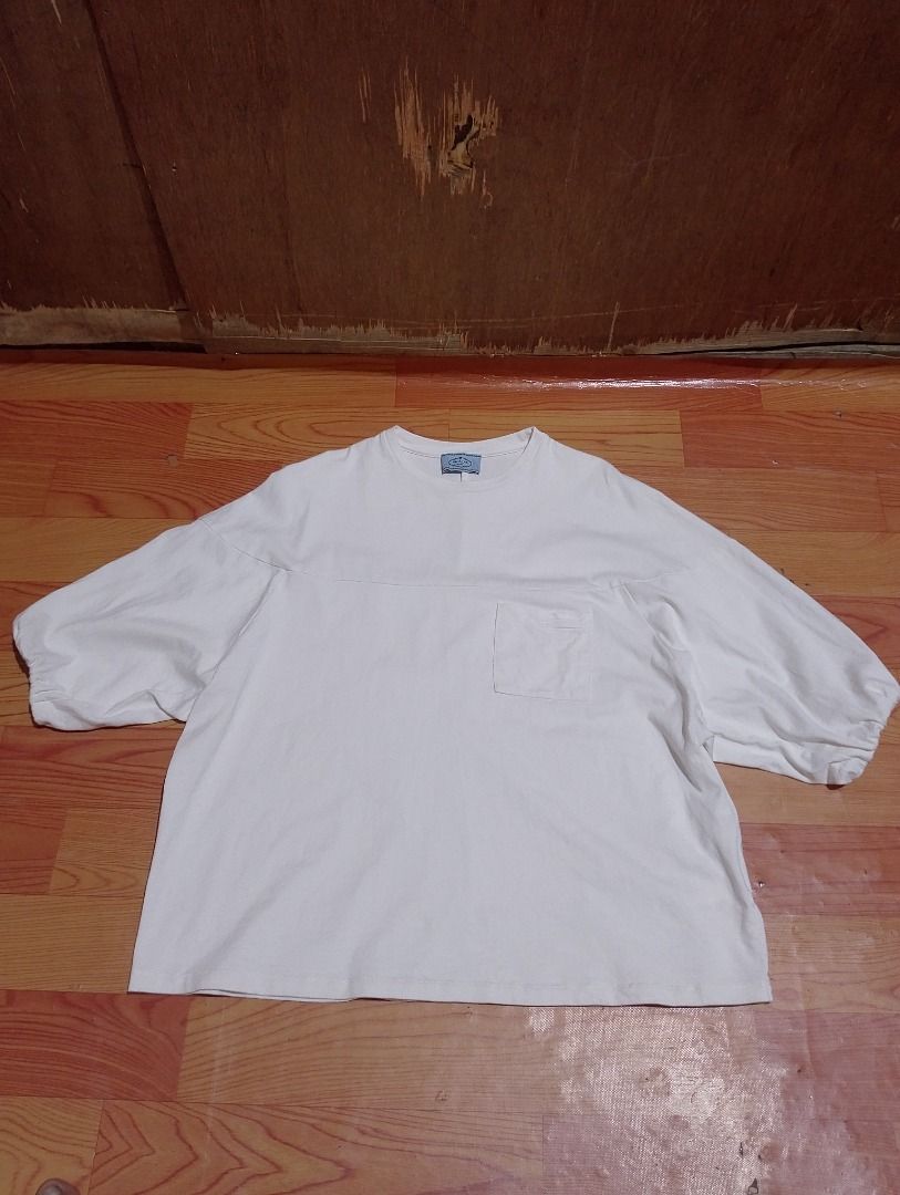 Prada White Pocket T-Shirt (Category: Shirts) located in Cavite. Submitted by marvzclothing (Listing ID 1468613196, Image 1). Description: - Brand: Prada - Color: White - Size: Small ( Fit to Medium) (Relaxed fit with dropped shoulders) - Origin: Made in Italy - Details: Chest pocket with fabric patch and gathered cuffs - Condition: Excellent, check photos for exact pit-to-pit measurement - Authenticity tag and care instructions included.