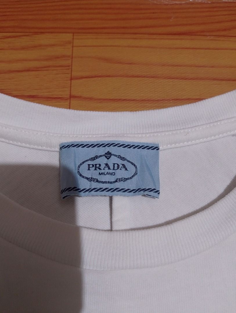 Prada White Pocket T-Shirt (Category: Shirts) located in Cavite. Submitted by marvzclothing (Listing ID 1468613196, Image 2). Description: - Brand: Prada - Color: White - Size: Small ( Fit to Medium) (Relaxed fit with dropped shoulders) - Origin: Made in Italy - Details: Chest pocket with fabric patch and gathered cuffs - Condition: Excellent, check photos for exact pit-to-pit measurement - Authenticity tag and care instructions included.