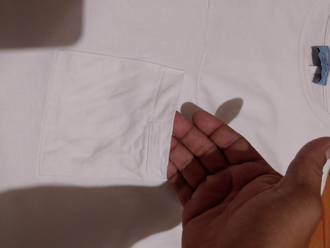 Prada White Pocket T-Shirt (Category: Shirts) located in Cavite. Submitted by marvzclothing (Listing ID 1468613196, Image 3). Description: - Brand: Prada - Color: White - Size: Small ( Fit to Medium) (Relaxed fit with dropped shoulders) - Origin: Made in Italy - Details: Chest pocket with fabric patch and gathered cuffs - Condition: Excellent, check photos for exact pit-to-pit measurement - Authenticity tag and care instructions included.