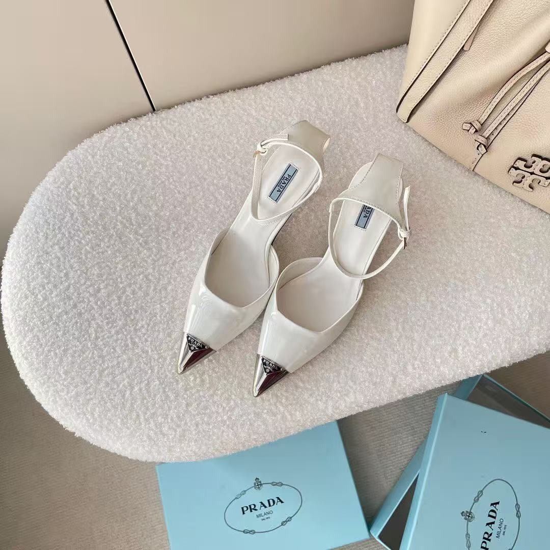 Prada White Slingback Heels with Silver Toe Cap (Category: Heels) located in Malabon City. Submitted by ojaswibent53454 (Listing ID 1468558431, Image 2). Description: - Brand: Prada - Style: Slingback stiletto heels with adjustable ankle strap buckle closure - Color: Clean white leather finish - Details: Pointed toe with silver-tone metal toe cap and signature Prada logo plaque - Inclusions: Original light blue Prada branded box as pictured - Con